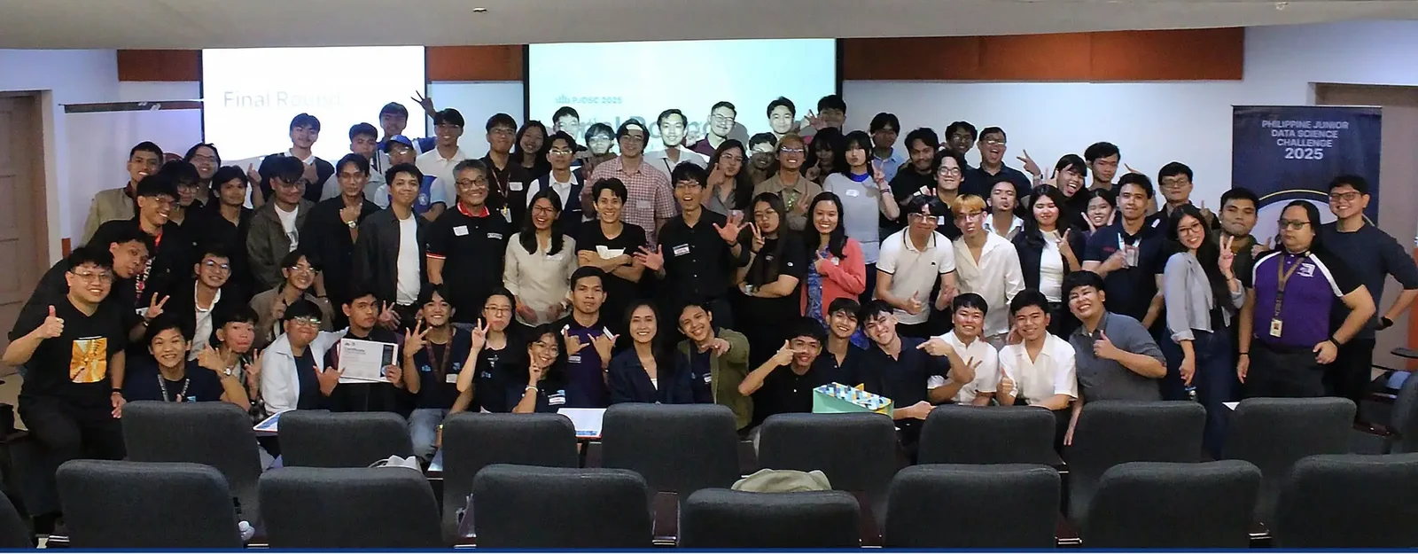PJDSC 2025 finalists, organizers, and speakers posing together in an auditorium after the final round, with the sponsor logos along the bottom.
